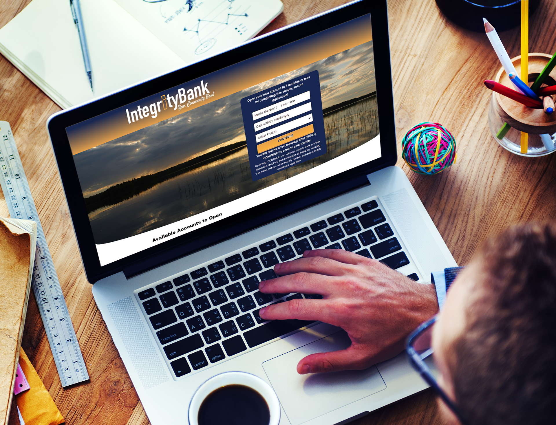 man working on laptop holding coffee cup
