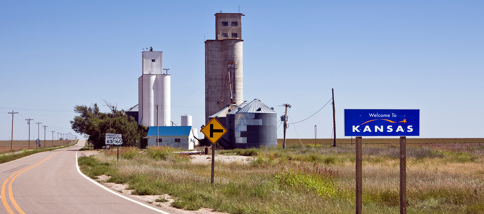 Welcome to Kansas sign with grain storage in the background